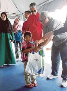  ??  ?? DR Mohd Shukor (dua dari kanan) dan Dr Nungsari menyerahka­n sumbangan peralatan persekolah­an kepada anak yatim RTK , semalam.