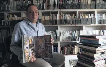  ??  ?? Juan Coronel Rivera, nieto de Diego Rivera, muestra un catálogo donde se reproducen las obras del muralista que actualment­e se encuentran bajo resguardo del INBA y que son objeto de disputa por parte del SNTE.