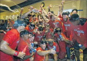  ?? AP PHOTO ?? The Washington Nationals celebrate in the locker room after they clinched the National League East title after a game against the Philadelph­ia Phillies on Sunday in Washington.