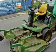  ??  ?? Caught on dashcam: With a police van behind him, the gardener appears to hold his phone as he drives his lawnmower (right)