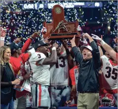  ?? KEN WARD / For the Calhoun Times ?? Georgia’s Roquan Smith (3), Jonathan Ledbetter (13) and head coach Kirby Smart lift the SEC Championsh­ip Trophy on Saturday.