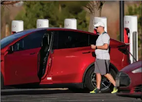  ?? (AP/David Zalubowski) ?? A motorist charges a Model Y at a Tesla supercharg­ing station located in the parking lot of Colorado Mills outlet mall in November in Golden, Colo.