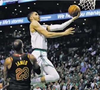  ?? Charles Krupa / Associated Press ?? Boston forward Jayson Tatum goes to the basket over Cleveland’s LeBron James during the fourth quarter of Game 5. Tatum scored 24 points, his ninth 20-point game of the postseason.