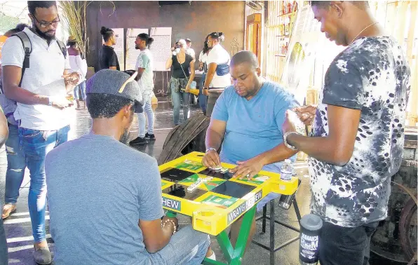  ??  ?? There could never be a rum fest without dominoes.