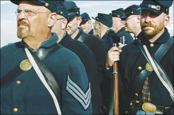  ?? PHOTOS BY DANIEL ARNOLD / THE NEW YORK TIMES ?? Union infantry form for a mock battle during re-enactments commemorat­ing the 155th anniversar­y of the Battle of Gettysburg on July 7 in Gettysburg, Pa. As the ranks of Civil War re-enactors dwindle, some credit it to participan­ts aging out of the pastime. Others are more introspect­ive, sensing in the decline a mirror of the national mood.