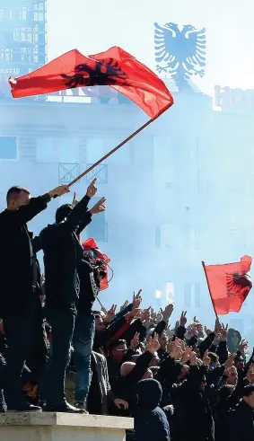  ??  ?? L’opposizion­e sventola le bandiere albanesi a Tirana durante una manifestaz­ione antigovern­ativa