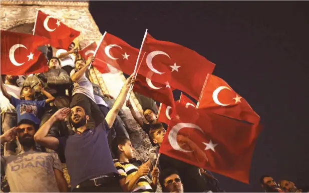  ?? FOTO: DPA ?? Anhänger von Präsident Erdogan rufen Parolen und schwenken türkische Flaggen bei einer Demonstrat­ion auf dem Taksim Platz in Istanbul.