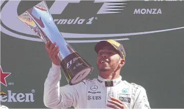  ?? REUTERS ?? Mercedes’ Lewis Hamilton celebrates with the trophy on the podium.