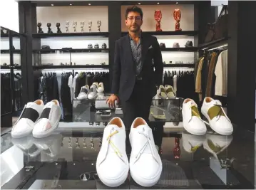 ??  ?? SYRIAN DESIGNER Daniel Essa poses with his prototype luxury sneakers displayed to be seen for online sale at a concept store in Lille, France, June 6.