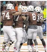  ?? DEBORAH CANNON / AMERICAN-STATESMAN ?? Texas celebrates a Tyrone Swoopes touchdown against Kansas State on Saturday. Swoopes had three rushing touchdowns in the 23-9 victory.