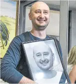  ?? GENYA SAVILOV/AFP/GETTY IMAGES ?? Anti-Kremlin journalist Arkady Babchenko holds a portrait of him that his colleagues displayed in his memory in the offices of his workplace, the ATR TV channel, in Kiev a day following his shocking reappearan­ce.