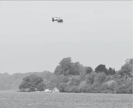  ?? JASON KRYK ?? A police helicopter flies over Lake Erie near Kingsville as part of the search Monday for a 25-year-old man whose canoe overturned.