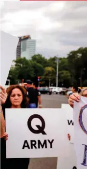  ?? ?? Junto a estas líneas, seguidores de QAnon durante una concentrac­ión de apoyo a las tesis conspirano­icas del misterioso personaje o personajes que se ocultan bajo tal apelativo. Derecha, J. F. Kennedy junior, fallecido en 1999.