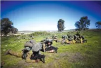  ?? (Ronen Zvulun/Reuters) ?? IDF SOLDIERS conduct a drill on the Golan Heights last week.