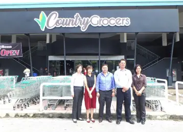  ??  ?? Wong, Bong, Siang, Kong and Tan from the Country Grocers Group pose for photo in front of the newly-opened supermarke­t.