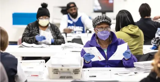  ?? ASHLEE REZIN/SUN-TIMES ?? Election workers process and count March 19 primary election mail-in ballots for the Chicago Board of Elections at the Cook County Administra­tion Building. A Republican-led lawsuit challenges Illinois’ counting of mail-in-ballots after election day, a move that has potential impact on this presidenti­al election year.