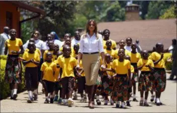  ?? CAROLYN KASTER - THE ASSOCIATED PRESS ?? First lady Melania Trump walks with singing children as she visits the Nest Orphanage in Limuru, Kenya, Friday, Oct. 5. Melania Trump has fed baby elephants as she visits a national park in Kenya to highlight conservati­on efforts. The U.S. first lady also went on a quick safari. Mrs. Trump is on her first-ever visit to Africa and her first extended solo internatio­nal trip as first lady.