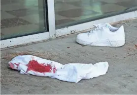  ?? MIKE DE SISTI / MILWAUKEE JOURNAL SENTINEL ?? A bloody shirt and a shoe remain at the scene near the corner of North Water Street and East Juneau Avenue.