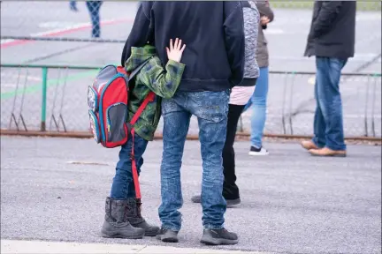  ?? The Canadian Press ?? A boy hugs his father as he waits to be called to enter the schoolyard at Marie-Derome School in Saint-Jean-sur-Richelieu, Que., on May 11.