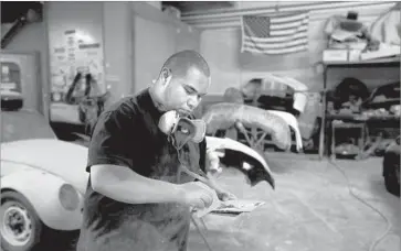  ??  ?? JONATHAN NIETO, 23, works at an auto body shop on 9th Street. He hopes one day to buy the shop — if he can secure a $20,000 loan — and enroll at Pasadena’s ArtCenter College of Design to become a car designer.