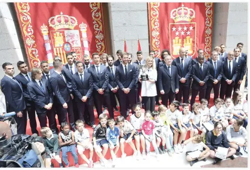  ??  ?? Real Madrid team poses with the president of Madrid, Cristina Cifuentes, at the Madrid Community headquarte­rs, in Madrid on Monday during a celebratio­n after the team won the Spanish league football tournament. (AFP)