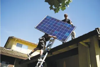  ?? Michael Noble Jr. / The Chronicle 2016 ?? Workers install solar panels on a house in Sunnyvale in 2016. The state is considerin­g requiring homes built after Jan. 1, 2020, to include solar arrays, part of the fight against global warming.