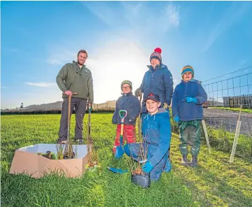  ?? Picture by Steve MacDougall. ?? PLANTING PROJECT: Iain Moss of the Woodland Trust, and Kate Maitland with sons Hamish, 4, Robbie, 9, and Ed, 8, at Dunbog Community Park yesterday.