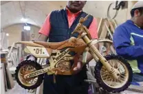  ?? ?? An inmate of the San Pedro prison shows a motorcycle he made with wood to be sold at the Alasita fair in La Paz.