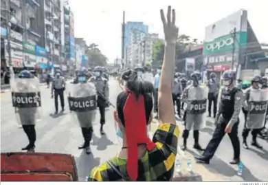  ?? LYNN BO BO / EFE ?? Una manifestan­te hace una señal con tres dedos, símbolo de resistenci­a, ante un grupo de policías en Rangún.