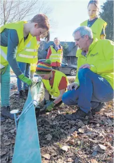  ?? FOTO: ELKE OBERLÄNDER ?? Ulfried Miller vom BUND Ravensburg zeigt Schülern der Gemeinscha­ftsschule Horgenzell, wie sie den Amphibienz­aun gut abdichten.