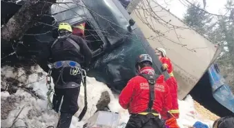  ??  ?? Search-and-rescue crews work to remove driver Pat Gaudet, of Oliver, who was trapped in the cab of his truck about 200 metres down an embankment in Manning Park on Thursday.