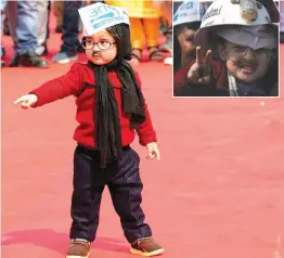  ?? — BIPLAB BANERJEE ?? ‘Little Mufflerman’ at the swearing-in ceremony of chief minister Arvind Kejriwal at Ramlila Maidan on Sunday. A child wears a helmet (top right) decorated with AAP symbol and picture of Mr Kejriwal.