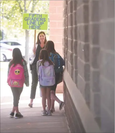  ?? H John Voorhees III / Hearst Connecticu­t Media file photo ?? School Counselor Jennifer Welton gathers fifth-graders as they get off the bus at Reed Intermedia­te School for their first day of school in Newtown in 2019.