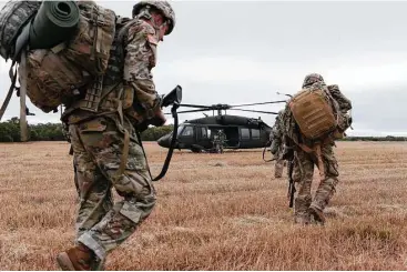  ?? Jerry Lara / San Antonio Express-News ?? Soldiers head back to base camp during the Army Best Medic Competitio­n at Camp Bullis in San Antonio. The once-isolated military training facility is threatened by encroachin­g developmen­t.