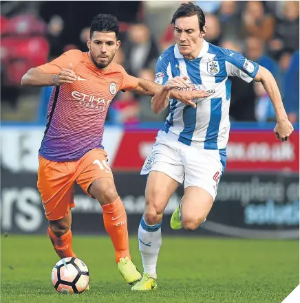  ??  ?? ■ Manchester City’s Sergio Aguero is put under pressure by Huddersfie­ld Town’s Dean Whitehead.