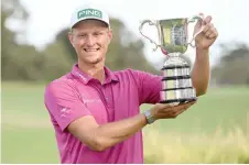  ?? — AFP photo ?? Poland’s Adrian Meronk holds the trophy a er winning the men’s Australian Open golf tournament at the Victoria course in Melbourne.