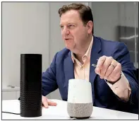  ?? AP/MARK LENNIHAN ?? In this photo taken earlier this month, Gareth Gaston, executive vice president and head of Omnichanne­l Banking at U.S. Bank, discusses voice assistant banking with an Amazon Echo, left, and a Google Home, right, in New York.