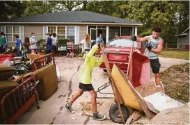  ?? Andrew Craft / Fayettevil­le Observer via Associated Press ?? Students help clean a Habitat for Humanity neighborho­od in Fayettevil­le, N.C., where more than 90 homes were damaged by flooding. More than 24,000 storm victims in North Carolina have applied for federal aid.