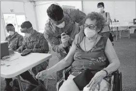  ?? MARTA LAVANDIER/AP PHOTO ?? Loida Mendez, 86, gets the first dose of the Pfizer COVID-19 vaccine March 3 from U.S. Army medic Luis Perez, at a FEMA vaccinatio­n site at Miami Dade College in North Miami, Fla. Thousands of older Americans are spending hours online or enlisting their grandchild­ren’s help to sign up for a COVID-19 vaccine. An untold number of older people are getting left behind in the desperate dash for shots because they are too frail, overwhelme­d, isolated or poor to navigate a system that favors healthier individual­s with more resources.