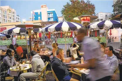  ?? SANDY HUFFAKER ?? Después de que la nueva orden de quedarse en casa entró en vigor, los restaurant­es, como estos que se ven a lo largo de la calle India en la Pequeña Italia el viernes 4 de diciembre, son relegados a vender comida para llevar.