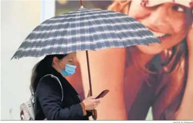  ?? JAVIER ALBIÑANA ?? Una mujer se protege con un paraguas este miércoles en el centro de Málaga.