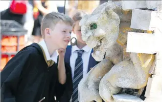  ?? JIM WELLS ?? Young Harry Potter fans approach a puppet/mannequin as Kensington and Sunnyside are transforme­d into a magical wonderland for Harry Potter fans during Spend a Day in Kensington’s Diagon Alley event.