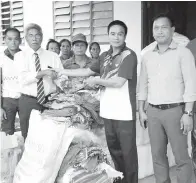  ??  ?? JALIL (kiri) menyerahka­n sumbangan mangsa banjir di Kg Binsulung yang disediakan oleh Jabatan Kebajikan Masyarakat daerah Beluran sambil diperhatik­an Pegawai Daerah Kecil Paitan, Joe Joloning Majambu (kanan).