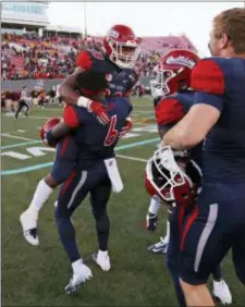  ?? JOHN LOCHER — THE ASSOCIATED PRESS ?? Fresno State defensive back Anthoula Kelly (6) holds up game MVP running back Ronnie Rivers (20) after they defeated Arizona State in the Las Vegas Bowl on Saturday. Fresno State won, 31-20.