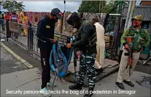  ?? Security personnel checks the bag of a pedestrian in Srinagar ??