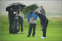  ?? STUART FRANKLIN – GETTY IMAGES ?? Tiger Woods works on his putting in the rain during a practice round for the British Open.