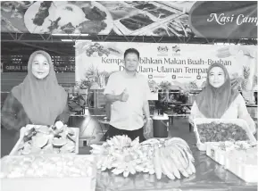  ??  ?? KEMPEN: Abdul Jaafar bersama warga kerja FAMA Sarawak mempromosi­kan Kempen Lebihkan Makan Buah-Buahan dan Ulam-Ulaman Tempatan di MNS.