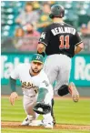  ?? RAY CHAVEZ/STAFF ?? The Marlins’ J.T. Realmuto beats the throw to A’s first baseman Yonder Alonso in the second inning on Tuesday.