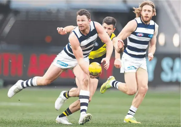  ??  ?? Geelong star Patrick Dangerfiel­d clears out of the middle in front of Richmond’s Trent Cotchin at the MCG. Picture: Michael Klein