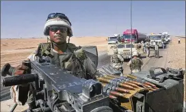  ?? ROB GRIFFITH / ASSOCIATED PRESS 2003 ?? An American soldier mans a 50-caliber machine gun as security for a fuel tanker convoy in Iraq. American military contractor­s have accused Baghdad of using strong-arm tactics to force them to pay exorbitant taxes.